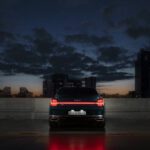 Autonomous Vehicle - The rear view of the Kia K9 parked facing the city buildings in the night.