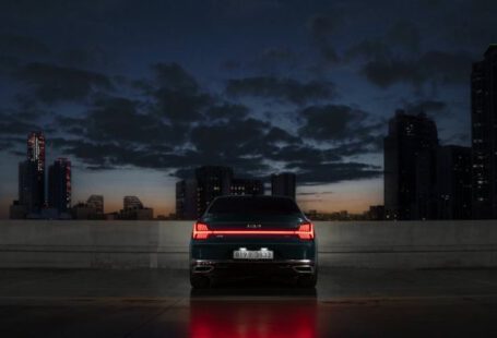 Autonomous Vehicle - The rear view of the Kia K9 parked facing the city buildings in the night.