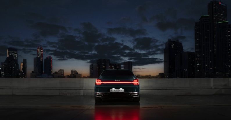 Autonomous Vehicle - The rear view of the Kia K9 parked facing the city buildings in the night.