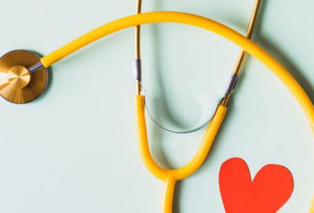 Heart Disease - Medical stethoscope with red paper heart on white surface