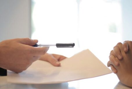 Credit Scores - Crop businessman giving contract to woman to sign