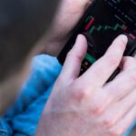 Financial Habits - A man is using his cell phone to look at the stock market