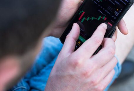 Financial Habits - A man is using his cell phone to look at the stock market