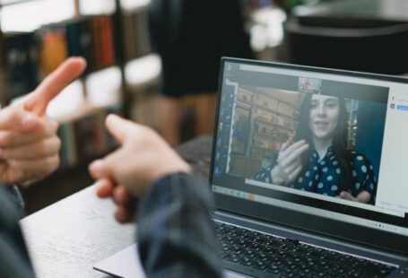 Language Preservation - Young lady learning sign language during online lesson with female tutor