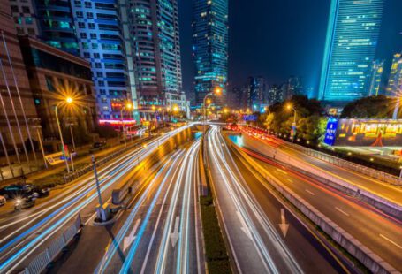 Smart Cities - Timelapse Photography of Vehicle on Concrete Road Near in High Rise Building during Nighttime