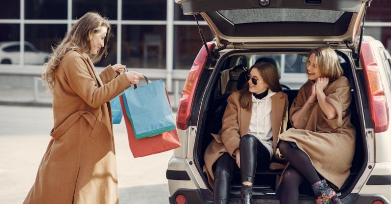 Mergers And Acquisitions - Young woman demonstrating shopping bags to friends