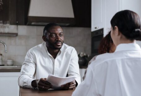 Corporate Social Responsibility - Afro-American Man and Caucasian Woman Having Meeting at Home with Social Worker