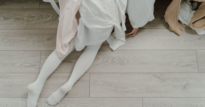 Fast Fashion - Woman Kneeling Near Cloths